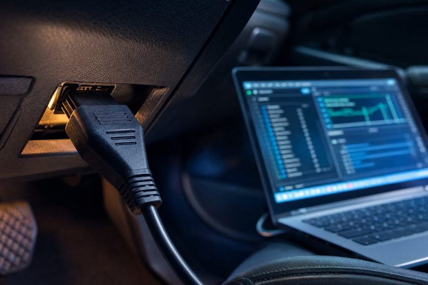 Interfață VCDS conectată la priza OBD a unei mașini din grupul VAG, cu laptop cu software de diagnoză